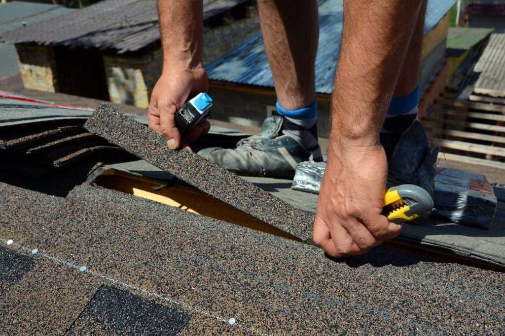 Repairing a roof by cutting shingles during a replacement | executive roofing