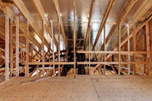 Attic space with wooden framing and reflective insulation, highlighting the importance of proper roof ventilation for energy efficiency and moisture control.